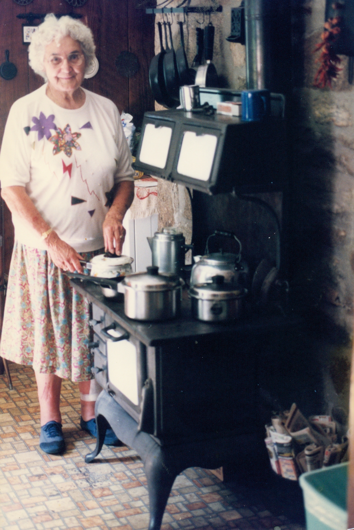 Verlon Edwards next to her wood cookstove